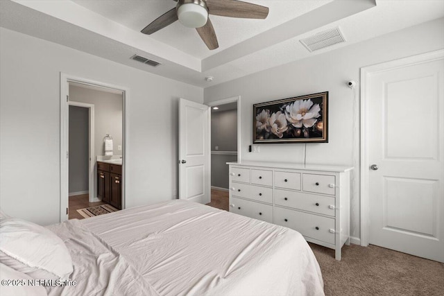 1580 Landau Rd, Jacksonville, FL 32225 - bedroom featuring light colored carpet, a tray ceiling, ensuite bath, a ceiling fan, and baseboards