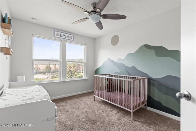 1580 Landau Rd, Jacksonville, FL 32225 - carpeted bedroom with baseboards, a nursery area, and ceiling fan