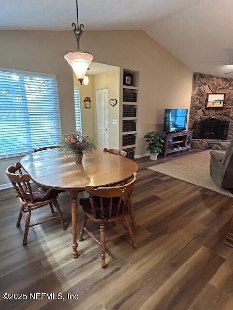 9360 Craven Rd # 607, Jacksonville, FL 32257 - dining area featuring lofted ceiling, wood finished floors, a stone fireplace, and baseboards