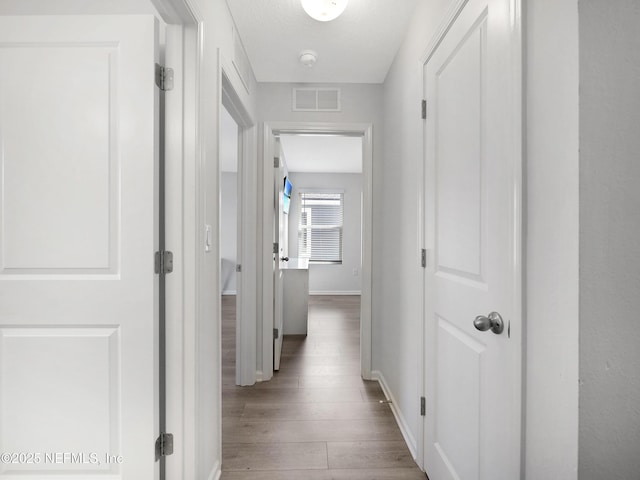 597 Meadow Ridge Dr, Saint Augustine, FL 32092 - hallway featuring baseboards, wood finished floors, and visible vents