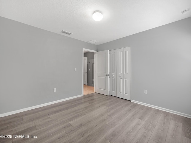 597 Meadow Ridge Dr, Saint Augustine, FL 32092 - unfurnished bedroom with visible vents, baseboards, wood finished floors, and a closet