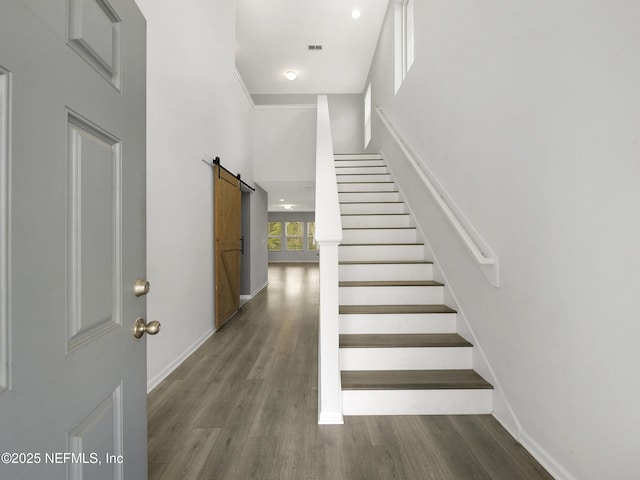 597 Meadow Ridge Dr, Saint Augustine, FL 32092 - stairway with baseboards, visible vents, a barn door, and wood finished floors