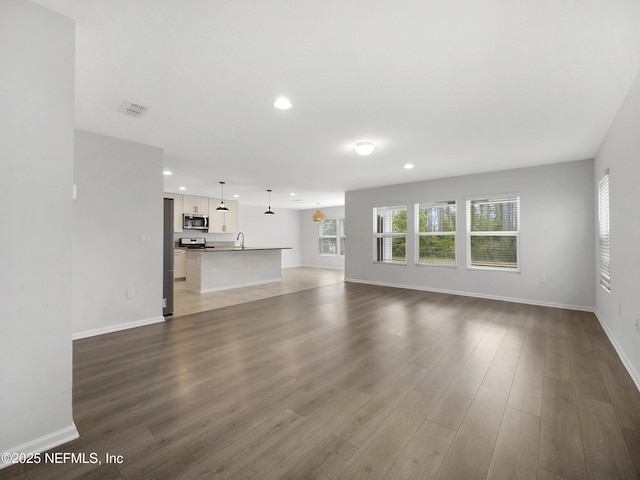 597 Meadow Ridge Dr, Saint Augustine, FL 32092 - unfurnished living room with recessed lighting, baseboards, and wood finished floors