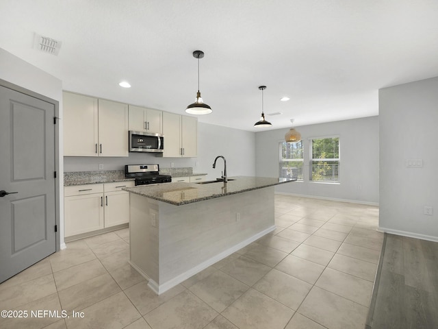 597 Meadow Ridge Dr, Saint Augustine, FL 32092 - kitchen with light stone counters, a sink, appliances with stainless steel finishes, and light tile patterned flooring