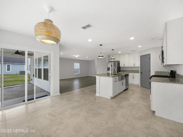597 Meadow Ridge Dr, Saint Augustine, FL 32092 - kitchen featuring visible vents, recessed lighting, dark stone counters, white cabinets, and stainless steel appliances