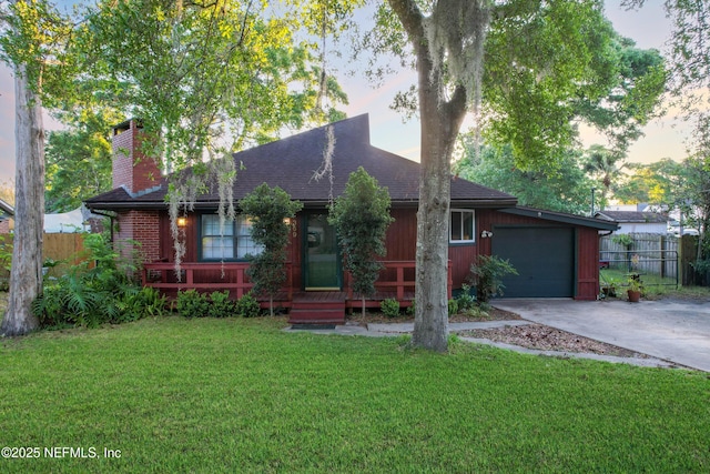 ranch-style house with a front lawn, driveway, a chimney, fence, and an attached garage