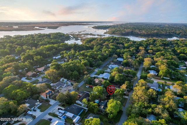 aerial view at dusk with a water view and a residential view