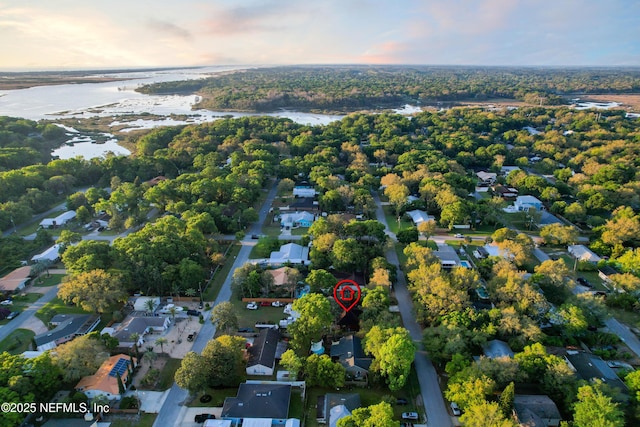 aerial view at dusk with a water view and a residential view