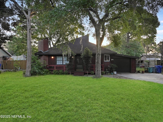 view of front of home featuring a chimney, fence, driveway, and a front yard