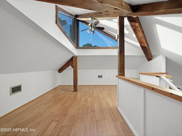 additional living space featuring wood finished floors, visible vents, and lofted ceiling with skylight