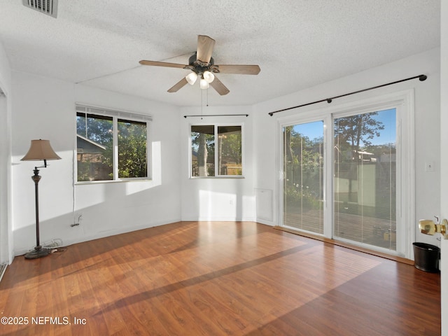 spare room with a textured ceiling, visible vents, and plenty of natural light