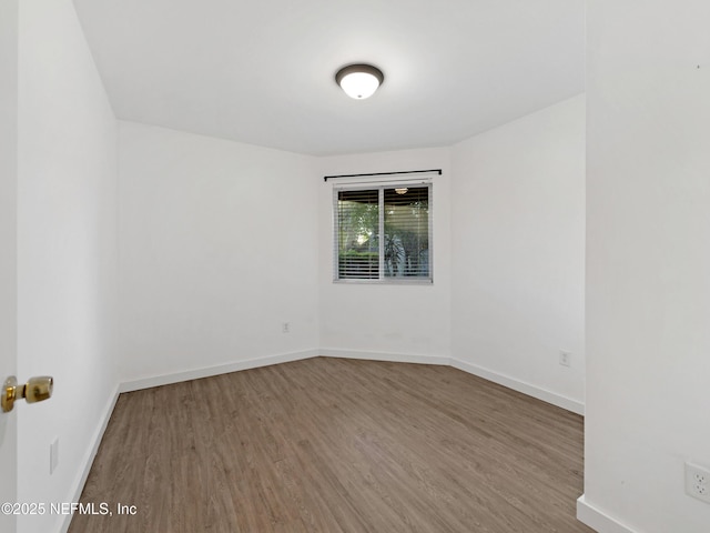unfurnished room featuring wood finished floors and baseboards