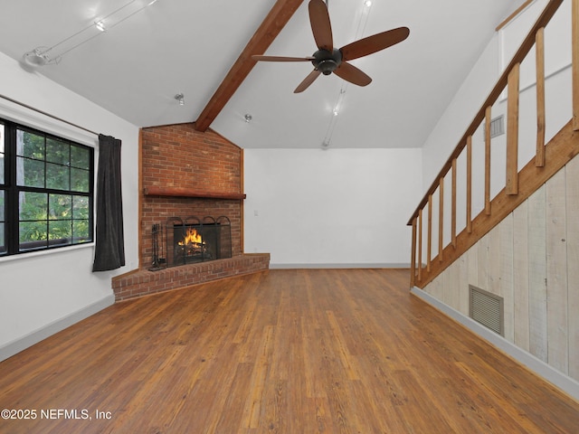unfurnished living room featuring stairs, wood finished floors, ceiling fan, a brick fireplace, and visible vents