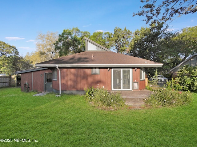 back of house featuring fence, a wooden deck, and a yard
