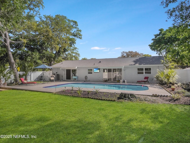 rear view of property featuring fence, a yard, and a fenced in pool
