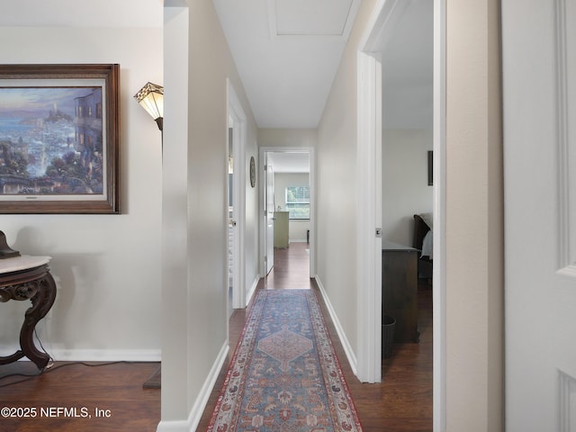 hall featuring baseboards and wood finished floors