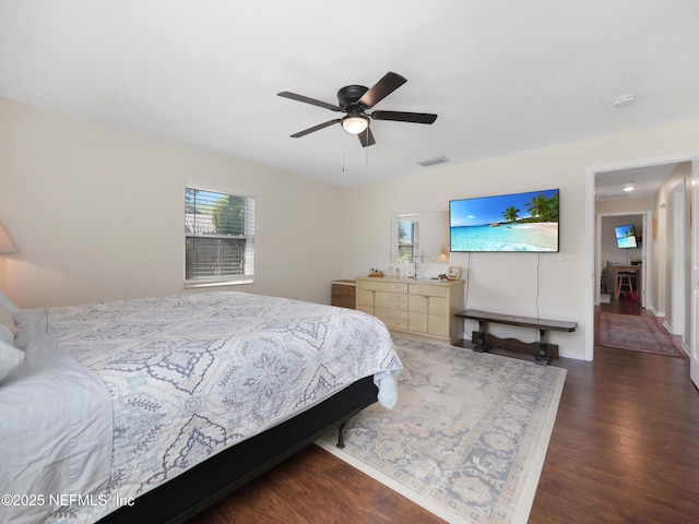 bedroom with ceiling fan, wood finished floors, and visible vents