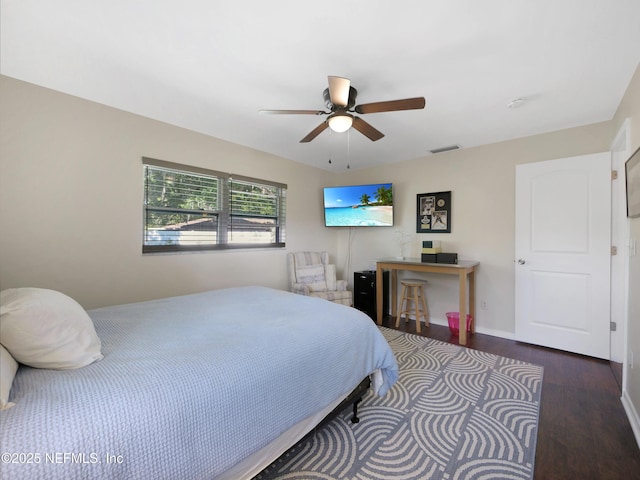 bedroom featuring baseboards, a ceiling fan, wood finished floors, and visible vents