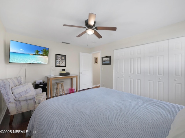 bedroom featuring a ceiling fan, a closet, baseboards, dark wood-style flooring, and visible vents
