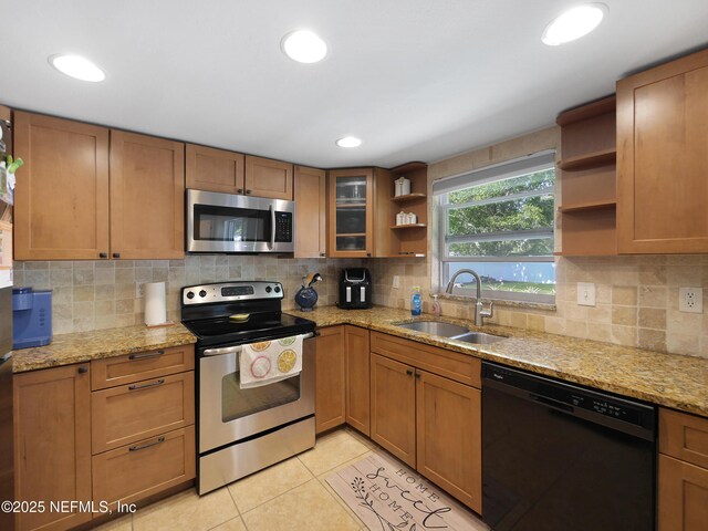 kitchen with brown cabinets, appliances with stainless steel finishes, open shelves, and a sink