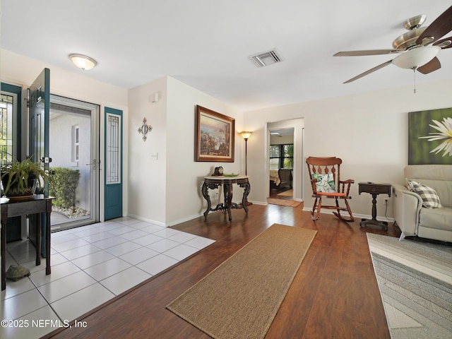 entrance foyer featuring baseboards, a ceiling fan, wood finished floors, and visible vents