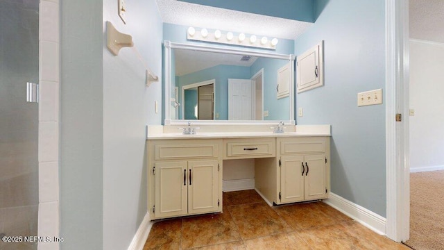 bathroom featuring walk in shower, double vanity, baseboards, and a sink