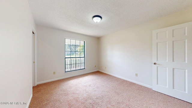 unfurnished room featuring baseboards, carpet floors, and a textured ceiling