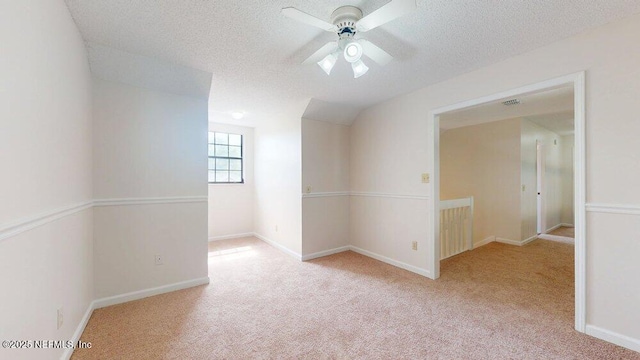 spare room featuring carpet floors, a ceiling fan, and a textured ceiling