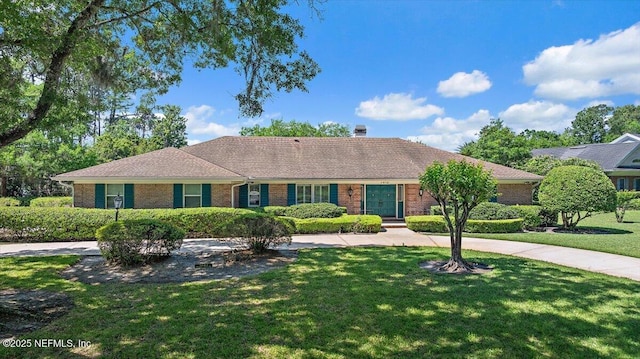 7812 Hunters Grove Rd, Jacksonville, FL 32256 - ranch-style house with a front yard, brick siding, and a chimney