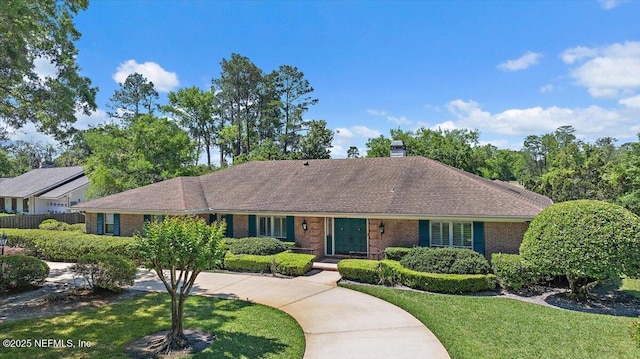 7812 Hunters Grove Rd, Jacksonville, FL 32256 - ranch-style house featuring roof with shingles, a chimney, a front lawn, brick siding, and fence