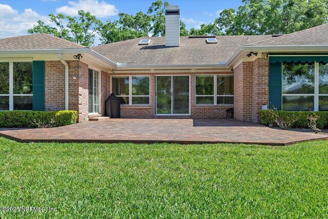 7812 Hunters Grove Rd, Jacksonville, FL 32256 - back of property featuring a shingled roof, a yard, brick siding, and a patio