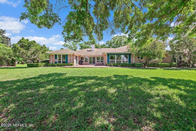 7812 Hunters Grove Rd, Jacksonville, FL 32256 - rear view of house with brick siding, a yard, and a chimney