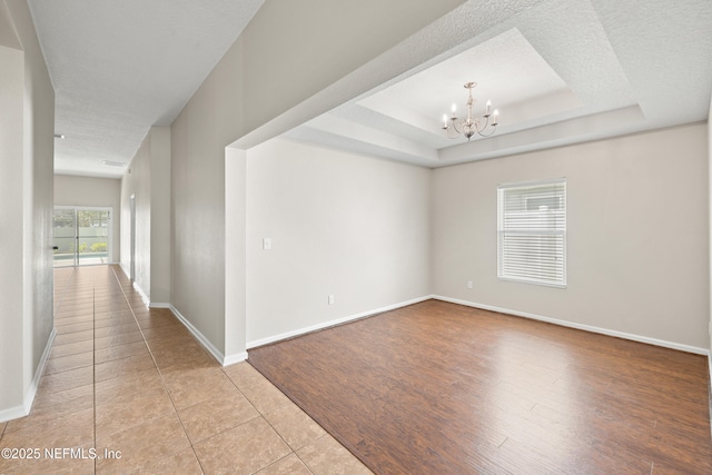 80 St Croix Island Dr, Saint Augustine, FL 32092 - tiled empty room featuring a chandelier and a tray ceiling