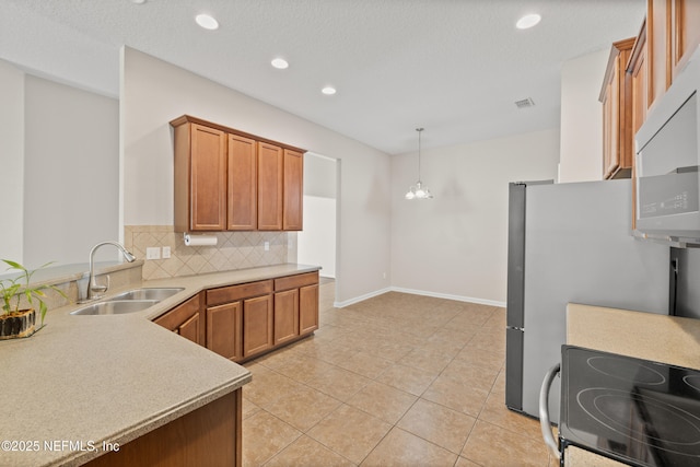80 St Croix Island Dr, Saint Augustine, FL 32092 - kitchen featuring range with electric cooktop, tasteful backsplash, light countertops, brown cabinetry, and hanging light fixtures