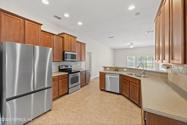 80 St Croix Island Dr, Saint Augustine, FL 32092 - kitchen with appliances with stainless steel finishes, brown cabinetry, tasteful backsplash, light tile patterned floors, and recessed lighting