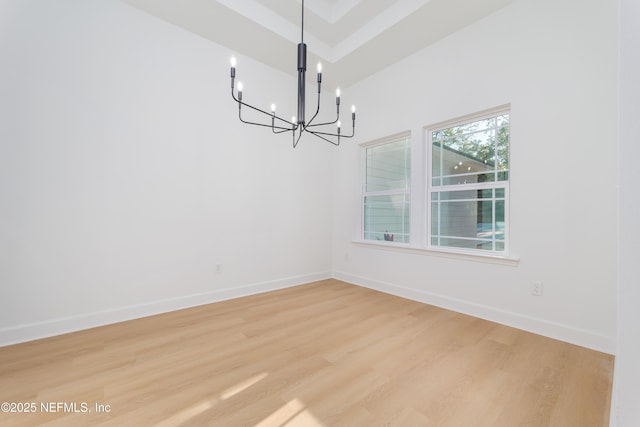 unfurnished dining area with light wood-style floors, baseboards, and an inviting chandelier