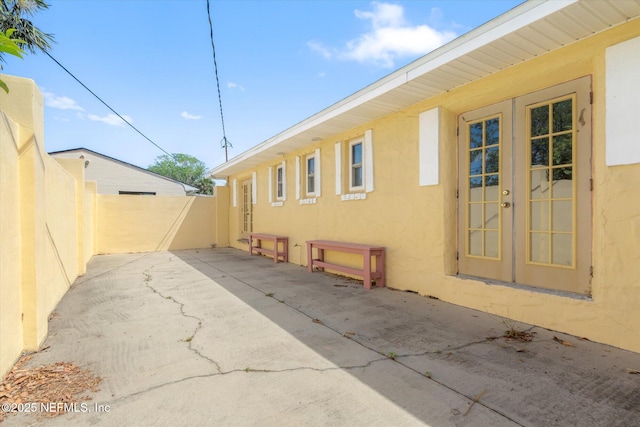 1800 N Halifax Ave, Daytona Beach, FL 32118 - view of property exterior featuring fence, a patio area, french doors, and stucco siding