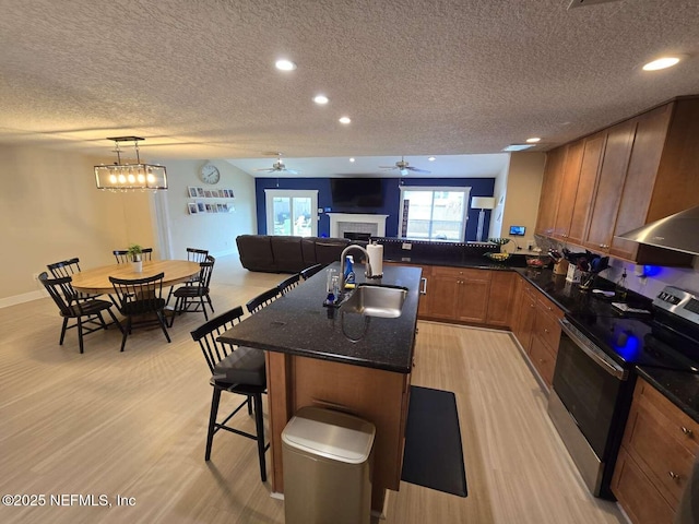 10 Quail Ln, Jacksonville Beach, FL 32250 - kitchen featuring a textured ceiling, a sink, stainless steel electric stove, and a fireplace