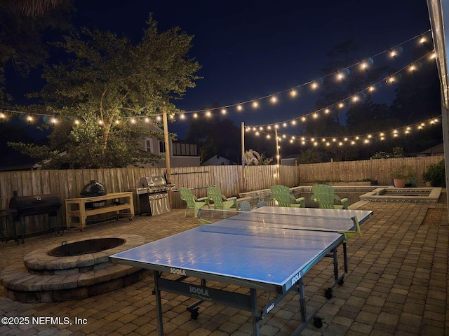 10 Quail Ln, Jacksonville Beach, FL 32250 - patio at twilight with a grill, outdoor dining area, a fenced backyard, and a fire pit