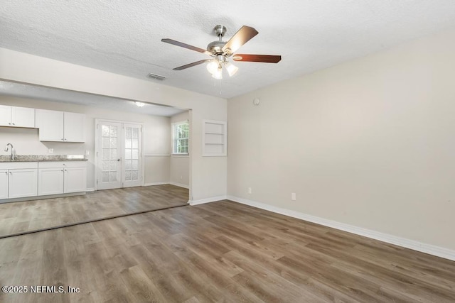 6504 Brandemere Rd S, Jacksonville, FL 32211 - unfurnished living room featuring light wood-type flooring, baseboards, a textured ceiling, visible vents, and ceiling fan