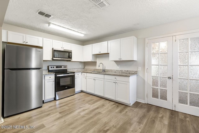 6504 Brandemere Rd S, Jacksonville, FL 32211 - kitchen featuring white cabinets, a textured ceiling, appliances with stainless steel finishes, and visible vents
