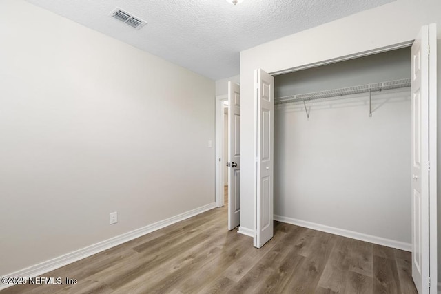 6504 Brandemere Rd S, Jacksonville, FL 32211 - unfurnished bedroom with a textured ceiling, a closet, visible vents, wood finished floors, and baseboards