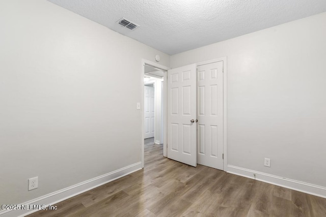 6504 Brandemere Rd S, Jacksonville, FL 32211 - unfurnished bedroom featuring visible vents, baseboards, wood finished floors, and a textured ceiling
