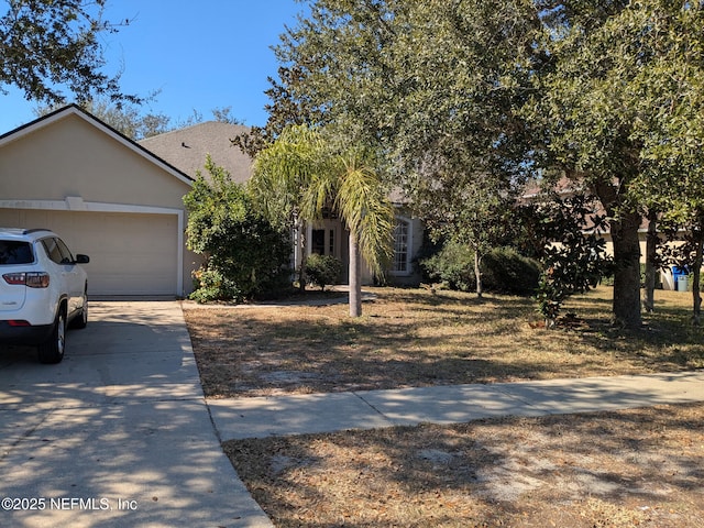 124 Hondo Dr, Saint Augustine, FL 32086 - obstructed view of property with a garage, stucco siding, and concrete driveway