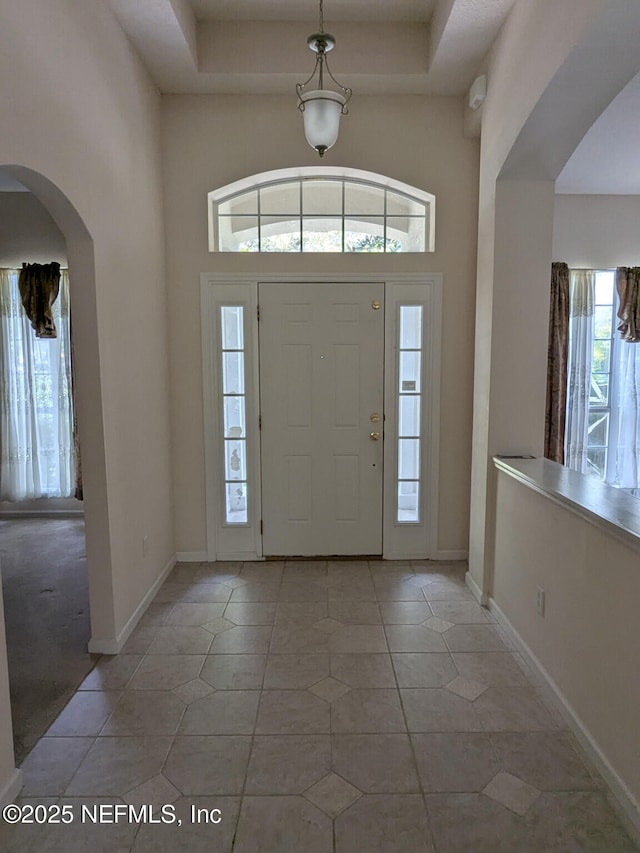 124 Hondo Dr, Saint Augustine, FL 32086 - entrance foyer featuring light tile patterned floors, baseboards, arched walkways, and a high ceiling