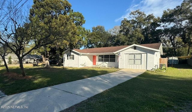 view of front facade featuring brick siding, driveway, fence, and a front lawn