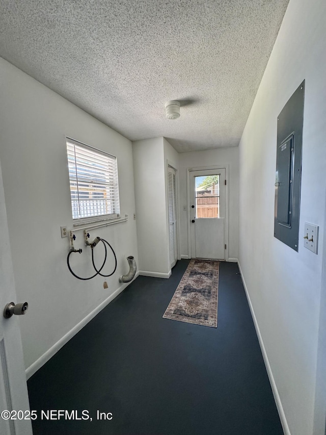 doorway with electric panel, a textured ceiling, baseboards, and carpet floors