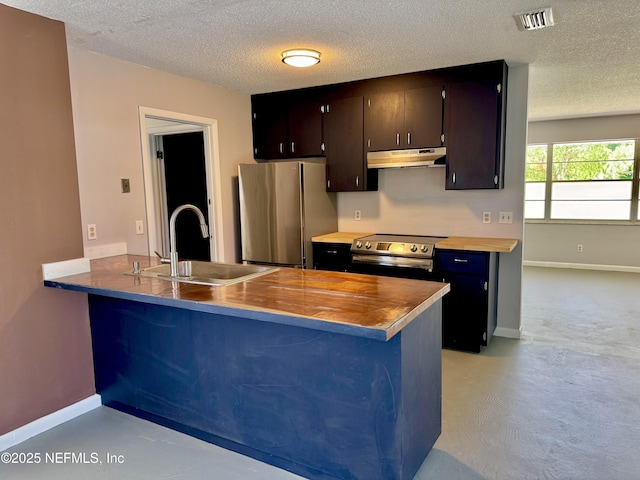 kitchen featuring a textured ceiling, visible vents, under cabinet range hood, a sink, and stainless steel appliances