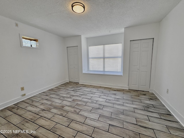 empty room featuring baseboards and a textured ceiling