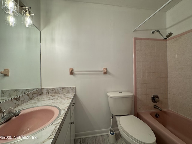 full bathroom featuring bathtub / shower combination, vanity, baseboards, and toilet